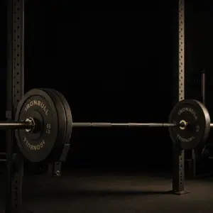 strength training for men over 30 – barbell loaded on squat rack in dark gym